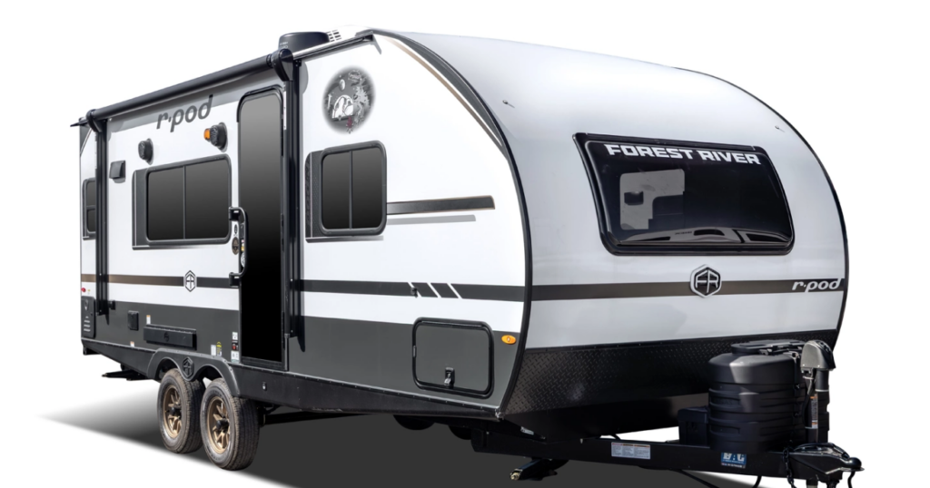 Forest River R-Pod travel trailer with compact white exterior, dual axles, black trim, and rounded aerodynamic front cap.