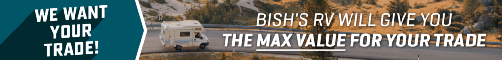 Promotional Bish’s RV trade-in banner featuring a motorhome driving through a scenic mountain road with text reading “We Want Your Trade!” and “Bish’s RV Will Give You the Max Value for Your Trade.