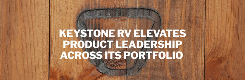 Wood-textured promotional graphic featuring the headline “Keystone RV Elevates Product Leadership Across Its Portfolio” in bold white lettering