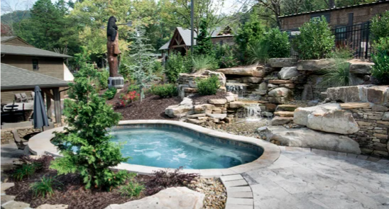 Relaxing hot tub and spa area at Little Arrow Outdoor Resort in Townsend, Tennessee, featuring natural stone waterfalls, landscaped gardens, and a tranquil mountain setting. Surrounded by lush greenery and rustic resort accommodations, the spa offers guests a peaceful retreat after exploring the Great Smoky Mountains.