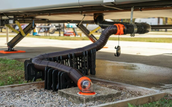 RV sewer hose connected to a campground dump station using a hose support system for proper drainage. The black tank waste hose is elevated and secured to maintain consistent flow, helping RV owners dump holding tanks safely, efficiently, and in accordance with campground sanitation best practices