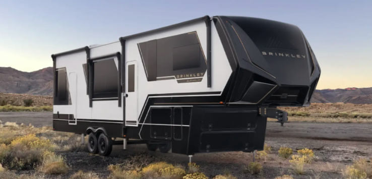 Brinkley fifth wheel RV showcasing a modern luxury exterior with a bold aerodynamic front cap, dual slide-outs, frameless windows, and expansive pass-through storage. Designed for full-time living and extended travel, the Brinkley fifth wheel combines premium construction, residential comfort, and high-end features for RVers seeking a luxury camping experience.