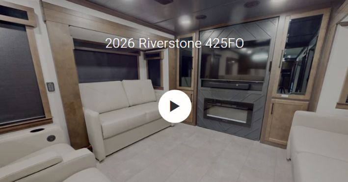 Interior of the 2026 Forest River RiverStone 425FO luxury fifth wheel featuring a spacious front living room with opposing residential sofas, a large entertainment center with fireplace, premium cabinetry, and panoramic windows. Designed for full-time RV living, the 425FO delivers residential comfort, upscale craftsmanship, and an open gathering space perfect for relaxing, entertaining, and extended RV travel.