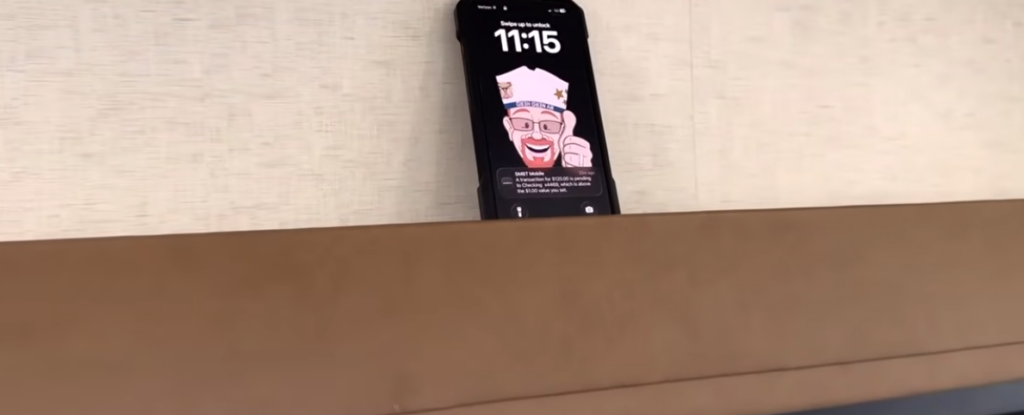 Built-in smartphone storage shelf inside the Modern Buggy Hopper travel trailer with a phone resting securely in place above the seating area.