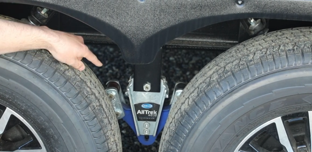 Close-up of the MORryde AllTrek 4000 equalizer suspension system installed between the tandem axles of an Outdoors RV travel trailer.