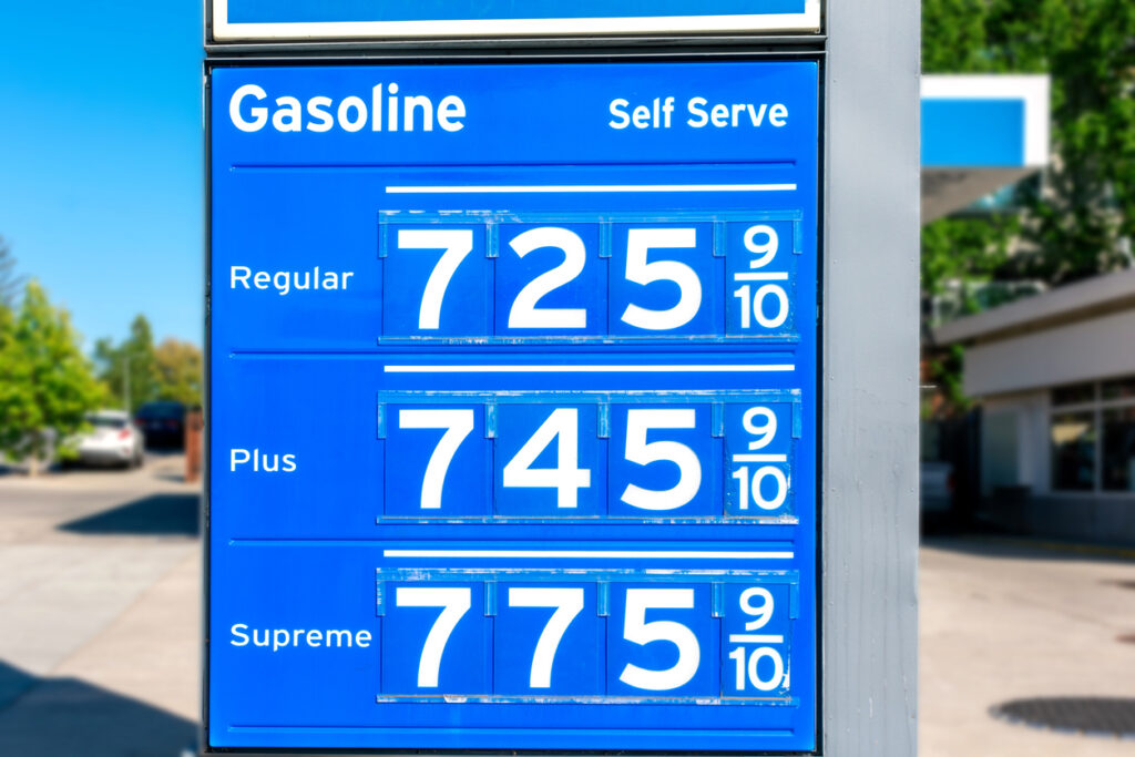 Gas station price sign displaying high gasoline prices for regular, plus, and premium fuel, illustrating rising fuel costs that impact RV travel and road trip budgets. The image represents increasing expenses for RV owners and highlights the importance of fuel-efficient trip planning and finding ways to save on camping and travel costs.